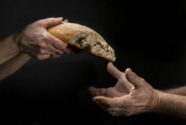 Один человек дают другому половину хлеба
